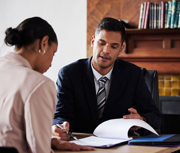 Man and woman discussing documents at desk.